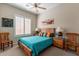 Bedroom with teal bedding, wooden furniture, and large window at 4333 S Pony Rider Trl, Gold Canyon, AZ 85118