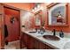 Bathroom featuring double sinks, copper finishes, and an adjacent toilet at 4333 S Pony Rider Trl, Gold Canyon, AZ 85118