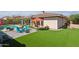 Relaxing backyard oasis with a pool, artificial turf, and patio seating at 18119 W Narramore Rd, Goodyear, AZ 85338