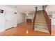 Home entryway with staircase, wood-look floors, and access to the kitchen at 18337 W Stinson Dr, Surprise, AZ 85374