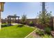 Landscaped backyard featuring a pergola and artificial turf at 22427 E Oriole Way, Queen Creek, AZ 85142
