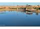 Serene lake with a reflection of homes and landscaping at 22427 E Oriole Way, Queen Creek, AZ 85142
