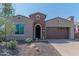 Single-story home with brick facade and two-car garage at 16917 W Sheridan St, Goodyear, AZ 85395