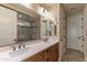 Double vanity bathroom with a large mirror and walk-in shower at 16917 W Sheridan St, Goodyear, AZ 85395