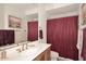 Clean bathroom with burgundy shower curtain, updated vanity, and a large mirror at 22455 N 55Th St, Phoenix, AZ 85054