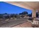 Covered patio with seating area, overlooking a tranquil water feature and desert landscaping at 22455 N 55Th St, Phoenix, AZ 85054