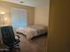Bedroom with a queen bed, office chair, and large window at 15682 W Jenan Dr, Surprise, AZ 85379