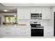 Sleek kitchen with white cabinets, stainless steel appliances, and quartz countertops at 9701 W Oak Ridge Dr, Sun City, AZ 85351