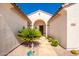 Front entry with a stone walkway, arched entryway, and lush landscaping at 18514 W Statler St, Surprise, AZ 85388