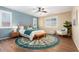 Spacious bedroom with wood floors, ceiling fan, and an accent wall at 18514 W Statler St, Surprise, AZ 85388
