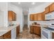 Kitchen features oak cabinets, tile floors, and a view into the hallway at 26 S Quinn Cir # 7, Mesa, AZ 85206
