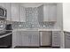 Modern kitchen with gray cabinets, stainless steel appliances, and tile backsplash at 7394 N 67Th Dr, Glendale, AZ 85303