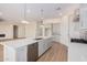 Open kitchen with white cabinets, large island, and stainless steel appliances at 16970 W Baker St, Surprise, AZ 85387