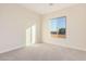 Bright bedroom with neutral walls and carpet, plus a window with a view at 16970 W Baker St, Surprise, AZ 85387