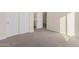 Well-lit bedroom with carpet flooring and double doors leading to a bathroom at 16970 W Baker St, Surprise, AZ 85387