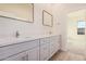 Elegant bathroom with double sinks, quartz countertops and a large mirror at 16970 W Baker St, Surprise, AZ 85387