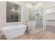 Luxurious bathroom with soaking tub, walk-in shower, and marble finishes at 16970 W Baker St, Surprise, AZ 85387