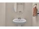 Small bathroom with pedestal sink and oval mirror at 18349 W Statler St, Surprise, AZ 85388