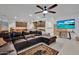 Spacious living room featuring a large sectional sofa, a large TV, and a ceiling fan at 14029 W Valentine St, Surprise, AZ 85379