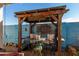 Relaxing patio area with a wooden pergola, seating, and decorative accents at 19104 N Smith Dr, Maricopa, AZ 85139