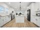 Modern kitchen with white cabinets, a large island, and stainless steel appliances at 8009 W Jadan St, Coolidge, AZ 85128