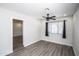 Bright bedroom with ceiling fan, wood-look floors, and access to another room at 2501 E Campbell Ave, Phoenix, AZ 85016