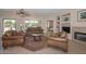 Living room with leather furniture, fireplace, and access to backyard at 17041 W Artesia Dr, Surprise, AZ 85387