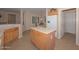 Kitchen with island, refrigerator, and access to hallway at 17041 W Artesia Dr, Surprise, AZ 85387
