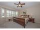 Bright bedroom with a king-size sleigh bed and window seat at 17041 W Artesia Dr, Surprise, AZ 85387