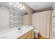 Bathroom with single vanity, patterned wallpaper, and shower/tub combo at 18809 N 39Th Way, Phoenix, AZ 85050