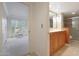 Bathroom with wood cabinets, a shower, and a view into bedroom at 5124 N 31St Pl # 534, Phoenix, AZ 85016