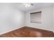 Empty bedroom with wood floors, ceiling fan, and window with blinds at 192 W Los Arboles Dr, Tempe, AZ 85284