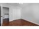 Bedroom with wood floors, double doors to closet, and access to bathroom at 192 W Los Arboles Dr, Tempe, AZ 85284
