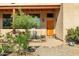 Inviting front porch with a wooden door, rocking chair, and landscaping at 44811 N 12Th St, New River, AZ 85087