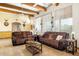 Living room with wood beams, two sofas, and a large TV at 44811 N 12Th St, New River, AZ 85087