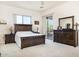 Bedroom with wood bed frame and access to patio at 44811 N 12Th St, New River, AZ 85087