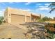 Exterior of a tan home with a three-car garage and desert landscaping at 44811 N 12Th St, New River, AZ 85087