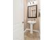 Modern powder room with pedestal sink and framed mirror at 3730 E Cat Balue Dr, Phoenix, AZ 85050