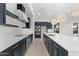 Modern kitchen with dark cabinetry, white countertops, and stainless steel appliances at 682 E Aurora Dr, San Tan Valley, AZ 85140