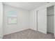 Empty bedroom featuring carpet flooring, a window, and a sliding closet door at 4233 E Bradford Ave, San Tan Valley, AZ 85143