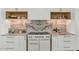 Sleek kitchen with marble backsplash, white cabinetry, and professional range at 6914 E 2Nd St, Scottsdale, AZ 85251