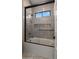 Modern bathroom with grey tile, glass shower, and built-in shelving at 29811 N 154Th St, Scottsdale, AZ 85262