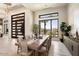 Bright dining room with a large wooden table and access to the backyard at 24351 N 97Th Dr, Peoria, AZ 85383