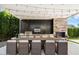 Modern outdoor kitchen with built-in grill, fireplace, and dining area at 24351 N 97Th Dr, Peoria, AZ 85383