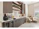 Modern wet bar with espresso machine, wine cooler, and ample storage at 24351 N 97Th Dr, Peoria, AZ 85383