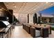 Modern outdoor kitchen with stainless steel appliances and a long dining table at 24351 N 97Th Dr, Peoria, AZ 85383