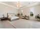 Luxurious main bedroom with plush bedding, sitting area, and large windows at 24351 N 97Th Dr, Peoria, AZ 85383