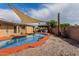 Inviting kidney-shaped pool with a shade sail and gravel surrounding at 3837 W Dailey St, Phoenix, AZ 85053