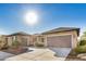 Tan house with brown roof, two car garage, desert landscaping at 20260 N 272Nd Ln, Buckeye, AZ 85396