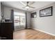 Well-lit bedroom with wood-look flooring and large window at 42999 W Samuel Dr, Maricopa, AZ 85138